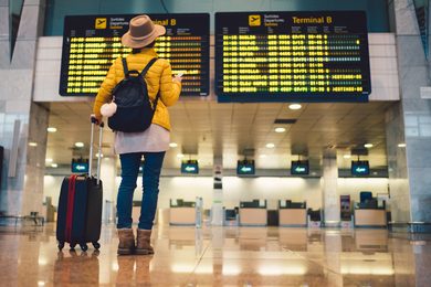Frau vor Anzeigetafel am Flughafen